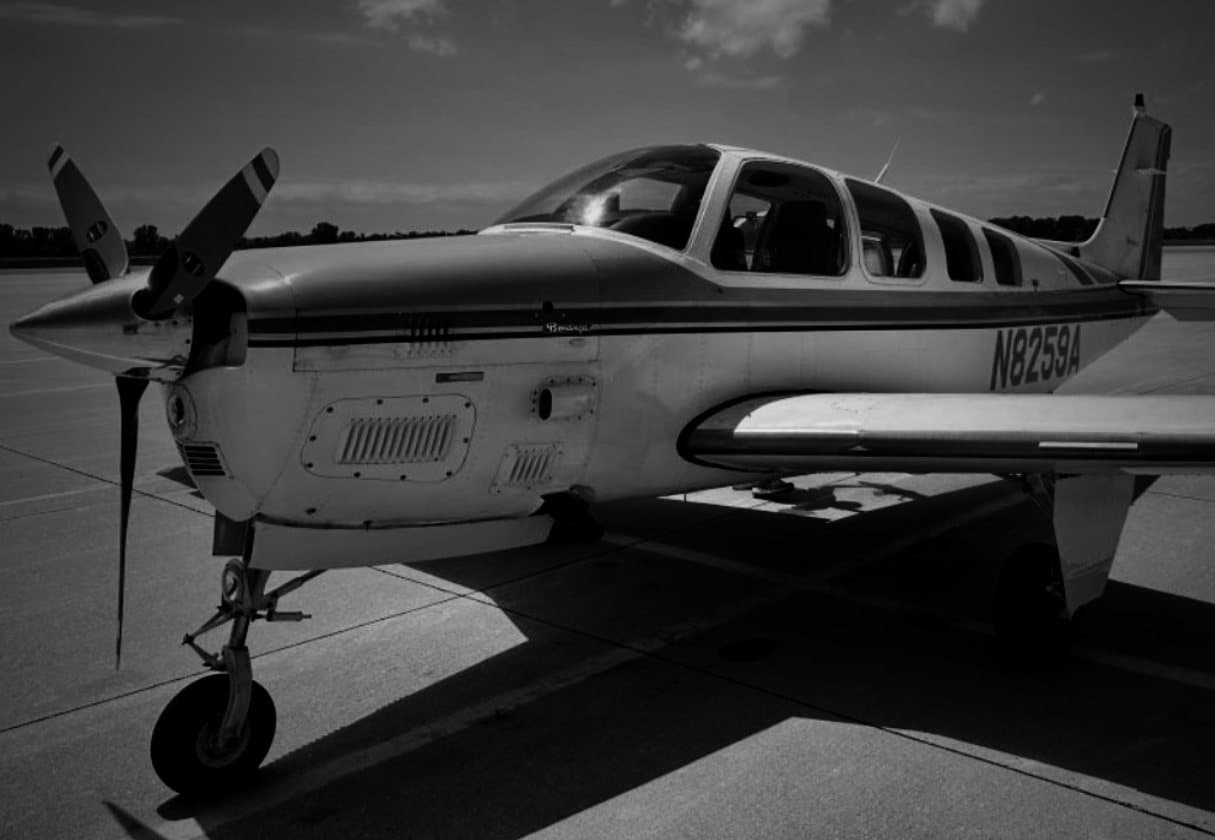 A Beechcraft Bonanza with the registration N8259A parked on an airport ramp, photographed in black and white.